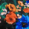 Satin de soie “Roses Solaire” – Fleurs orange sur fond nuit – 100% soie – 140 cm Fleurs multicolores sur fond vert et bleu