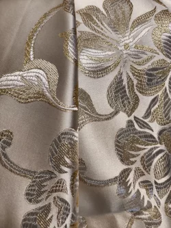 Tissu brodé motifs floraux dorés brillants.