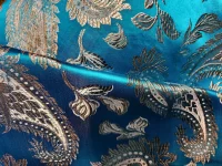 Tissu brodé bleu avec motifs dorés.