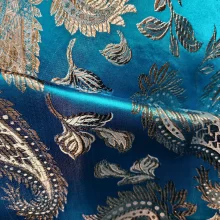 Tissu brodé bleu avec motifs dorés.