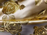 Tissu doré avec motifs de roses brodées.