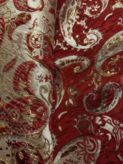 Tissu brocart rouge motif paisley doré élégant.