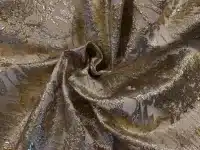 Tissu doré et argenté avec motifs floraux.
