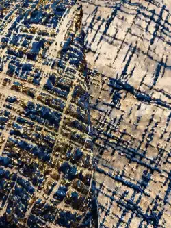 Tissu brodé bleu et doré avec motifs géométriques.
