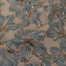 Tissu brodé bleu et or avec motif floral.