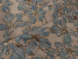 Tissu brodé bleu et or avec motif floral.