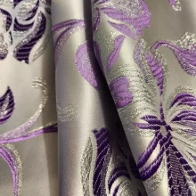 Tissu brocart violet et argent, motif floral lumineux.